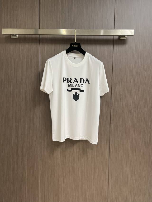 Prada 胶印字母短袖t恤，平纹针织t恤秉承品牌简约而华美的理念，已然演变为一种态度，一种重释基础单品，焕新设计内涵的不懈追求。品牌标志性的刻字徽标以胶印拼接