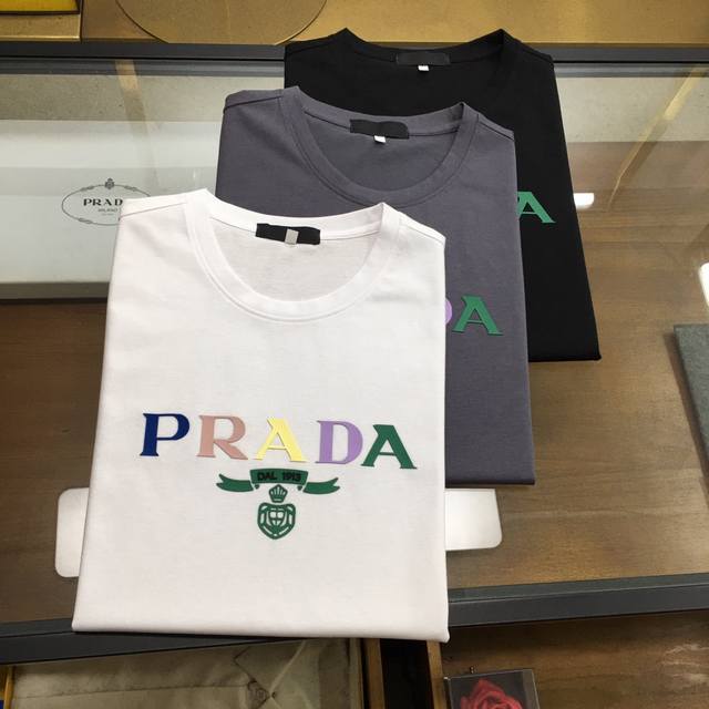 新品 Prad... 2024春夏新款首发专柜最新款短袖圆领t恤 高端订制 设计前卫时尚！品牌logo重工艺设计 高端定制230克面料.手感柔软.穿着舒适.专柜