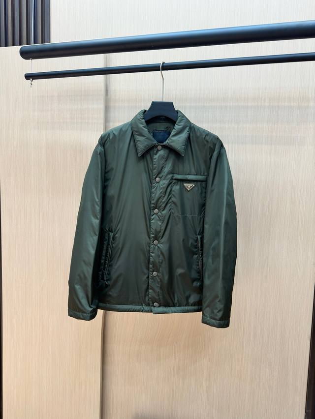 新品 Prada普拉达新款提花尼龙羽绒服金属小标羽绒服。羽绒服采用re-Nylon再生尼龙打造，现代设计风格,和廓形相得益彰，采用95的白鸭绒给予更温暖防护标志