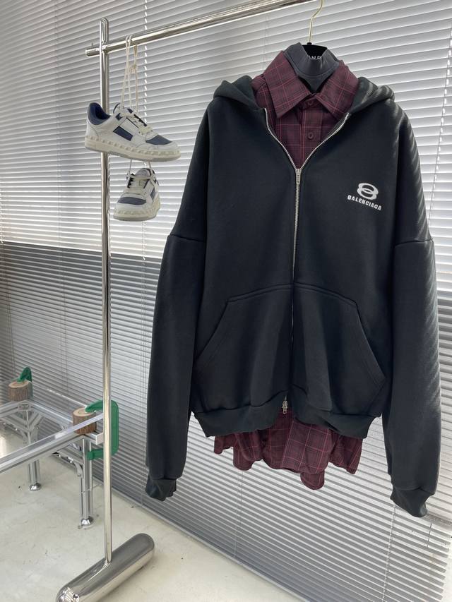 Balenciag 24Ss新款连帽卫衣，黑色面料、酒红色棉质格纹法兰绒和黑色复古平纹针织大廓形连帽卫衣， 胸部饰以unity Sports Icon艺术作品刺