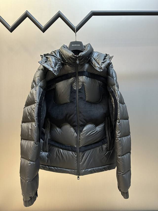 Moncler 蝙蝠侠标识羽绒服 定制墨韵高级炭黑涂层风衣面料，定制韩韵流光丝绒针织面料，采用400D压光胆布，国标95白鸭绒，冲绒量十足。饰以蝙蝠侠标识点缀正